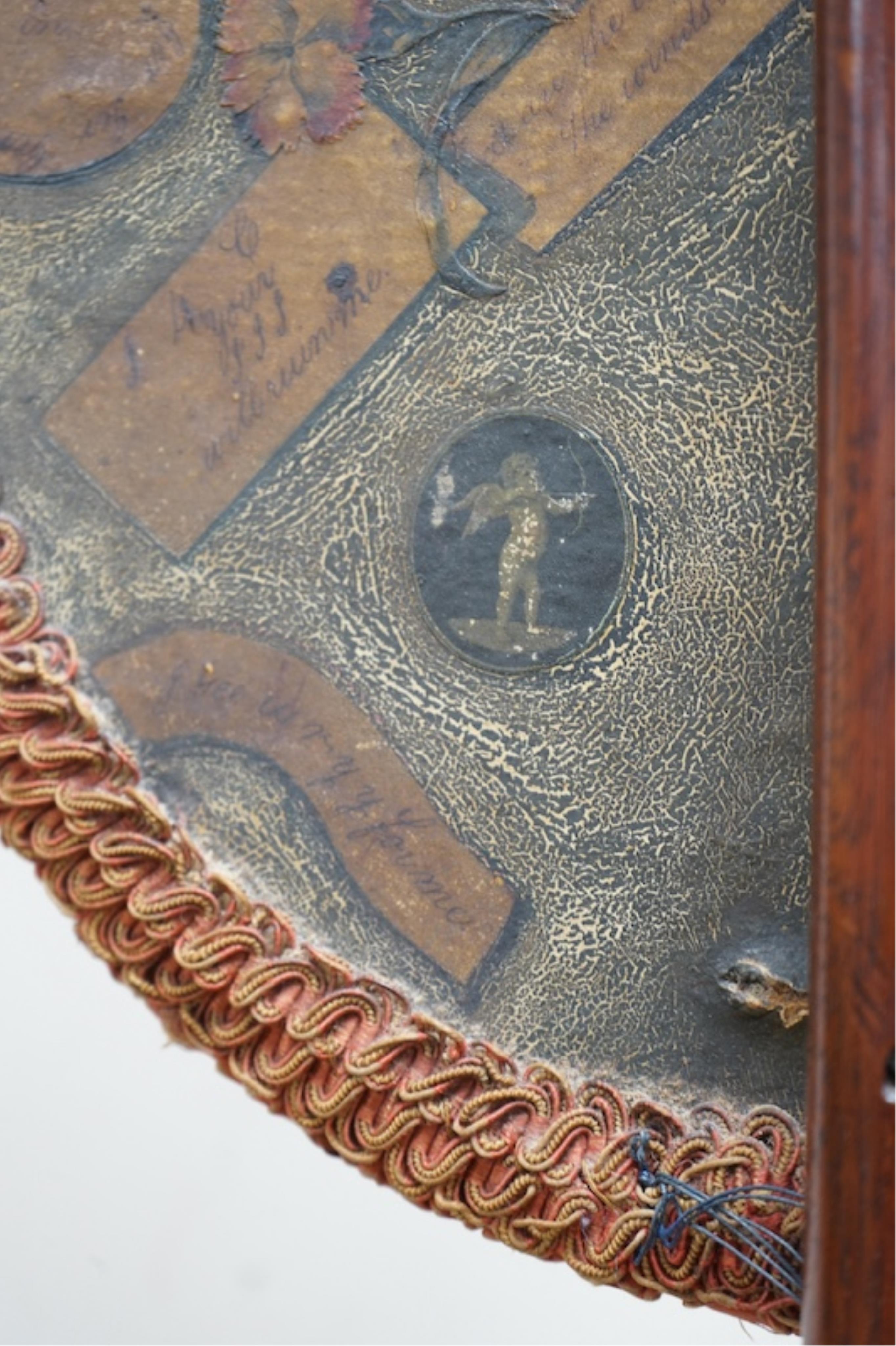 An oval Regency fire screen painting of a shepherd boy with his dog and a painting verso of ephemera, the screen edged with rushed ribbon fixed to a simple mahogany stand. 130cm high. Condition - paintings crazed and rib